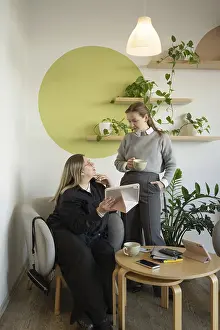 Two women engage in conversation in a cozy cafe setting