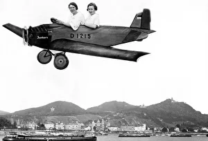Two women fly into a cardboard plane over the Rhine