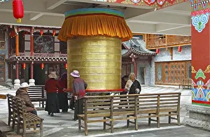 Women turn a prayer wheel, Kangding