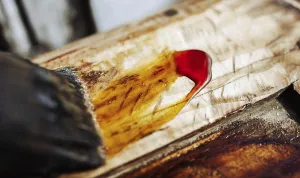 Wood being stained with yellow and red hues