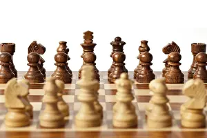 Wooden chess pieces on chessboard