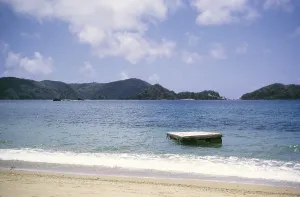 Wooden diving platform in the sea off a sandy beach in island of Tobago, 1962