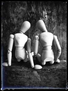 Two wooden figures are positioned closely together