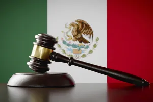 Wooden gavel resting on table in front of mexican flag