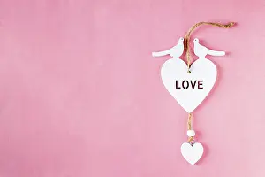 Wooden heart on pink background, copy space