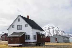 Wooden house in front of a mountain peak