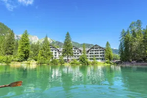 Wooden oar stroking emerald green water of lake braies