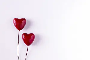 Two wooden red hearts on white background