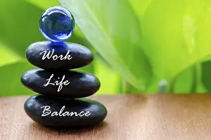 Work Life Balance text on black zen stones with blue glass marble on top