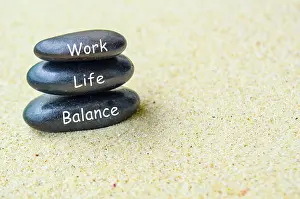 Work life balance text on black zen stones on sandy beach