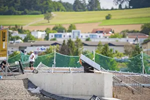 A worker on a construction site assembling solar panels in a rural area