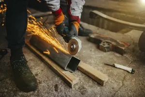 A worker grinding metal with sparks flying