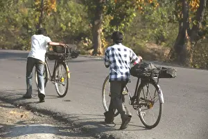 Workers from coal mine carrying lump of coal loaded back seat of bicycles in Jharkhand