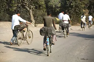 Workers from coal mine carrying lump of coal loaded back seat of bicycles in Jharkhand