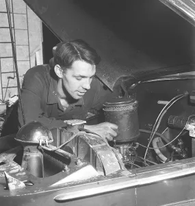 Working on the engine 1946. A mechanic in a garage is seen working on the motor and the air filter. Sweden 1961. Kristoffersson ref U14-2