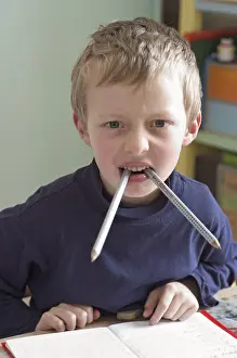 Six year old boy sitting at desk doing homework