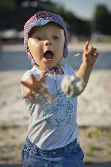 A two year old boy throwing a sand ball in Wroclaw
