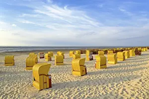Yellow beach chairs in the evening light at the beach of Cuxhaven-Dose