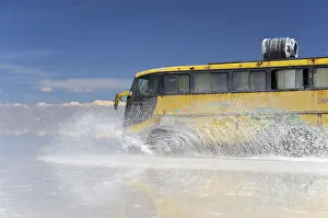 Yellow bus driving across the Salar de Uyuni