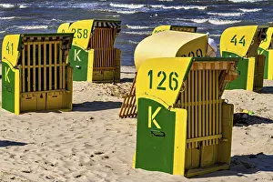 Yellow and green beach chairs stand in the sun on the beach with a view of the sea