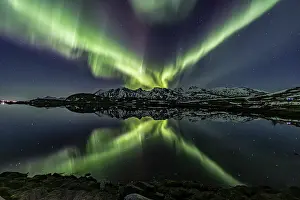 Yellow and green northern lights reflected in fjord