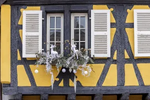 Yellow half-timbered house with a window decorated for Christmas
