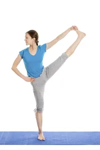 Yoga, young beautiful slender woman yoga instructor doing Extended Hand-To-Big-Toe Pose (Utthita Hasta Padangustasana)