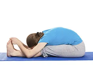 Yoga, young beautiful slender woman yoga instructor doing Seated Forward Bend or Intense Dorsal Stretch pose asana