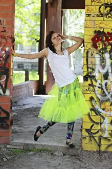 Young attractive girl brunette near the walls with graffiti