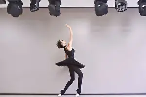 Young ballet dancer black swan practicing before performance in black tutu