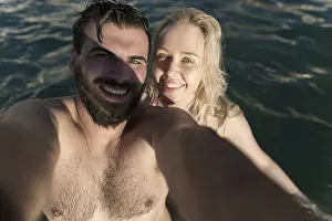 Young and beautiful couple taking selfie at the sea