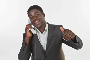 Young black man in a suit making a phone call in an office