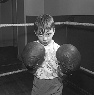Young boxer in the 1950s. A boy wearing boxing gloves photographed in the boxing ring