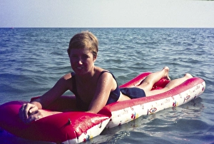 Young British woman on holiday floating in sea of inflated lilo, Spain, 1966, Europe