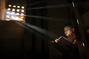 Young Buddhist monk reading in monastery