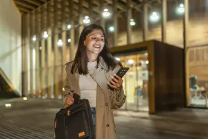 Young businesswoman smiling while checking her smartphone
