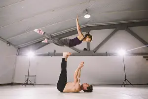 Young couple Couple practicing acro yoga in gym