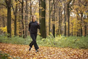 Young dark-haired woman during fitness training in an autumn forest