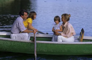 Young family with 2 two children in a rowing boat