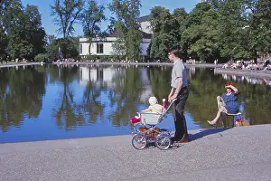 Young father with stroller many people sitting on chairs in the sun in 1967 at Eckensee