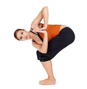 Young fit woman practicing yoga exercise called: Twisted Chair Pose sanskrit name: Parivrtta Utkatasana