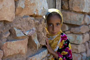 Faces Of The World Prints: Young girl, berberine, looking curiously from behind a wall