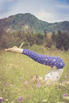 Young girl is doing yoga in the park