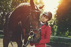 A young girl talking and takes care of her horse