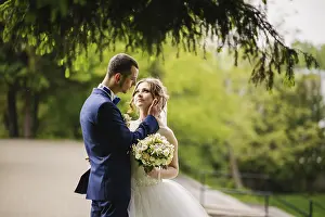 Young lovely and cheerfull wedding couple walking at the park