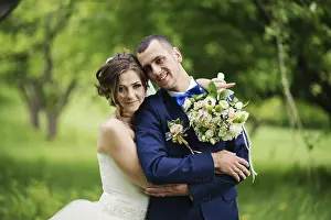 Young lovely and cheerfull wedding couple walking at the park