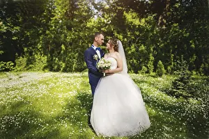 Young lovely and cheerfull wedding couple walking at the park