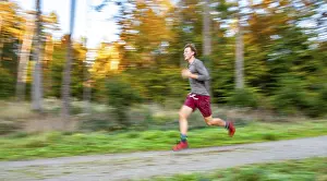 Young man jogging in the autumnal forest