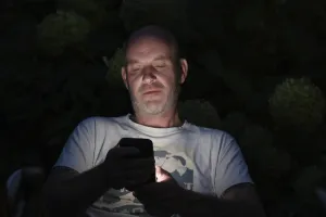 Young man on mobile phone at night