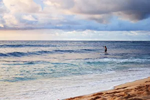 Young man stand up paddling in the sea